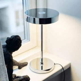 Starlight 25cm Kromi pöytävalaisin valmistajalta Dyberg Larsen - Med inbyggd LED och tre ljusstyrkor, som dimras med 3-stegsdimmern p&aring; lamphuvudet, anpassar den sig enkelt efter olika behov &ndash; fr&aring;n st&auml;mningsfullt sken till fokuserat ljus.