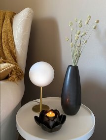 Molekyl 27cm Matta messinki pöytävalaisin valmistajalta Aneta Lighting - Pienen kokonsa ja opaalinvalkoisen lasivarjostimen ansiosta se levitt&auml;&auml; miellytt&auml;v&auml;&auml;, pehme&auml;&auml; valoa, joka luo kutsuvan tunnelman.