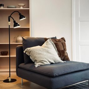 Lilje Musta lattiavalaisin valmistajalta Dyberg Larsen - Lily golvlampa i svart och m&auml;ssing kombinerar modern design med flexibilitet och funktionalitet.