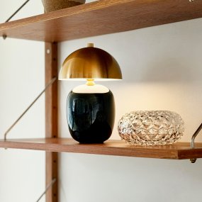 Manhatten 23cm Musta/messinki Siirrettävä valmistajalta Dyberg Larsen - Lampun jalka on valmistettu mustasta keramiikasta, jossa on kiilt&auml;v&auml; pinta, ja se on tyylikk&auml;&auml;sti yhdistetty tumman messinginv&auml;riseen metallivarjostimeen, mik&auml; luo modernin mutta ajattoman ilmeen.