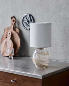 Hite 44cm Luonnonvalkoinen pöytävalaisin valmistajalta House Doctor - Tyylik&auml;s norsunluunv&auml;rinen pellavavarjostin t&auml;ydent&auml;&auml; lasijalkaa ja levitt&auml;&auml; pehme&auml;&auml; ja miellytt&auml;v&auml;&auml; valoa.