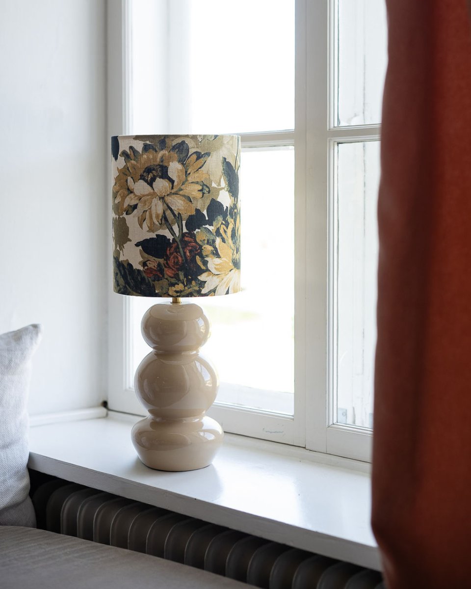 Lampshade Cylinder Sunflower Ø22 Monivärinen valmistajalta Alde & Lind - Sylinterimäinen auringonkukka on käsinommeltu, sylinterinmuotoinen pellavasekoitteesta valmistettu lampunvarjostin, jossa on koristeellinen kukkakuvio.
