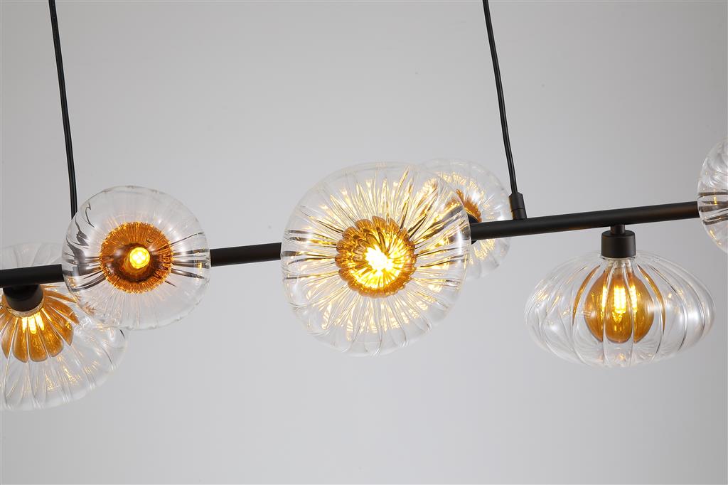 Sunbeam 90cm Läpinäkyvä/musta kattovalaisin valmistajalta Searchlight - Seitsemän uurrettua varjostinta läpinäkyvästä lasista, joissa on lämmin meripihkanvärinen kupu, on sijoitettu mattamustan metallitangon varrelle, luoden ilmeikkään muotoilun, joka yhdistää toiminnallisuuden ja koristeellisen taiteen.