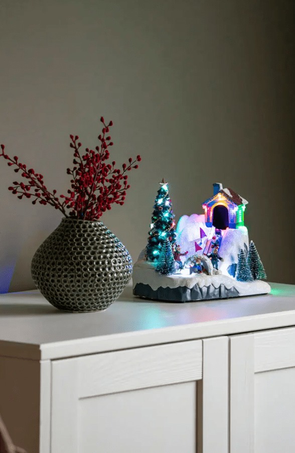 Talvimaisema LED 18cm Monivärinen valmistajalta Konstsmide - Winterland on varustettu 6 tunnin ajastimella ja toimii 3 AA-paristolla tai mukana tulevalla 180 cm:n USB-kaapelilla.
