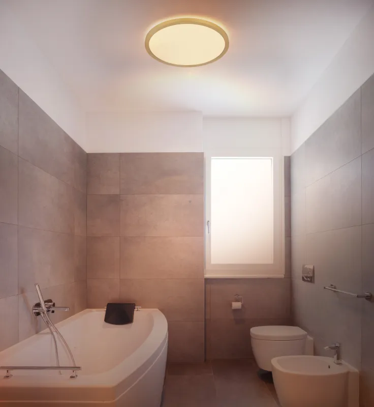 Sapana Ø30 Messinki kylpyhuoneen valaisin valmistajalta Globo Lighting - Lampan &auml;r tillverkad av matt m&auml;ssingsf&auml;rgad och vit plast, vilket ger ett mjukt och bl&auml;ndfritt ljus.