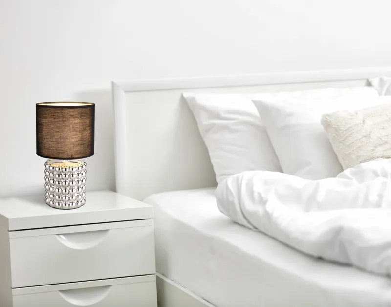 Valentino 33cm Kromi pöytävalaisin valmistajalta Globo Lighting - P&aring; en cylinderformad fot i krompl&auml;terad keramik vilar en stilren, svart textilsk&auml;rm.