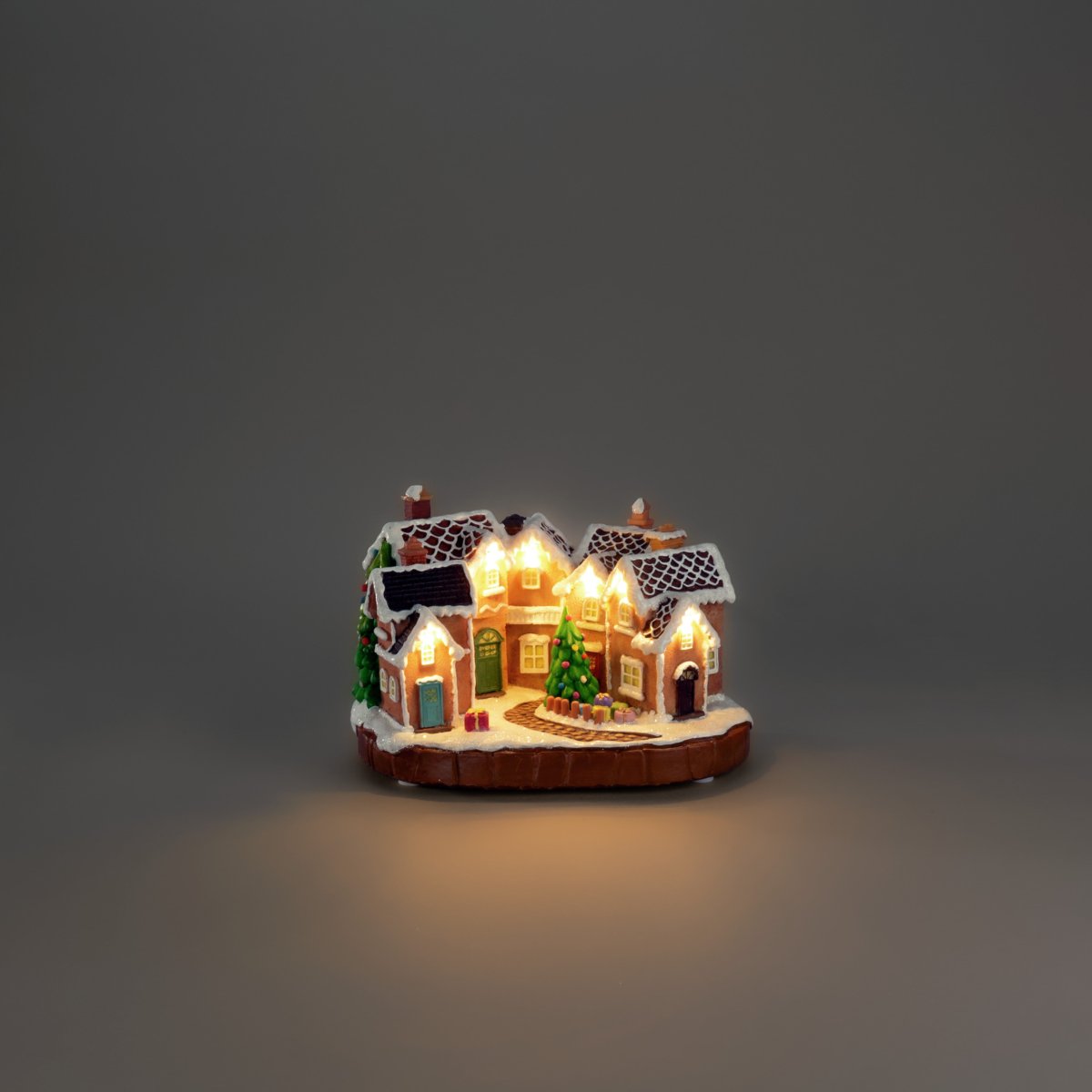 Piparkakkukylä 17cm Ruskea valmistajalta Konstsmide - Lumipeitteiset katot, v&auml;rikk&auml;&auml;t ovet ja koristeltu joulukuusi keskell&auml; luovat satumaisen joulutunnelman.