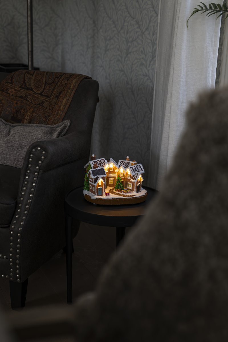 Piparkakkukylä 17cm Ruskea valmistajalta Konstsmide - Lumipeitteiset katot, v&auml;rikk&auml;&auml;t ovet ja koristeltu joulukuusi keskell&auml; luovat satumaisen joulutunnelman.