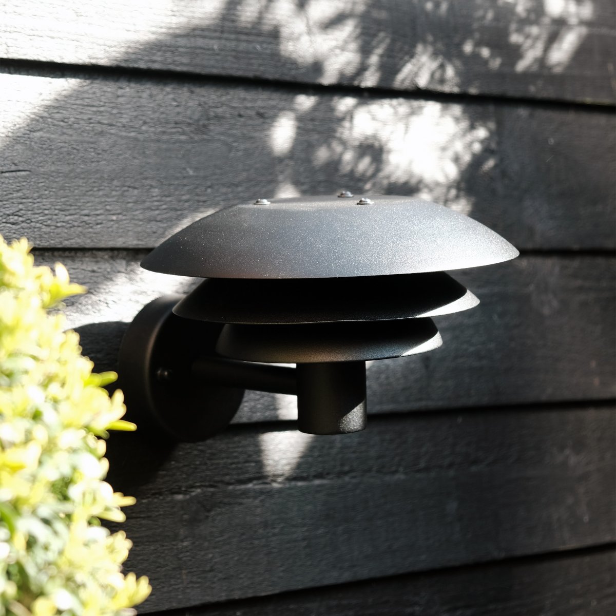 DL20 Musta ulkovalo valmistajalta Dyberg Larsen - Valaisimessa on kolme erikokoista ikonista varjostinta, jotka levittävät maagista valoa, ja se on valmistettu ruostumattomasta teräksestä eleganteilla mattamustilla sävyillä.