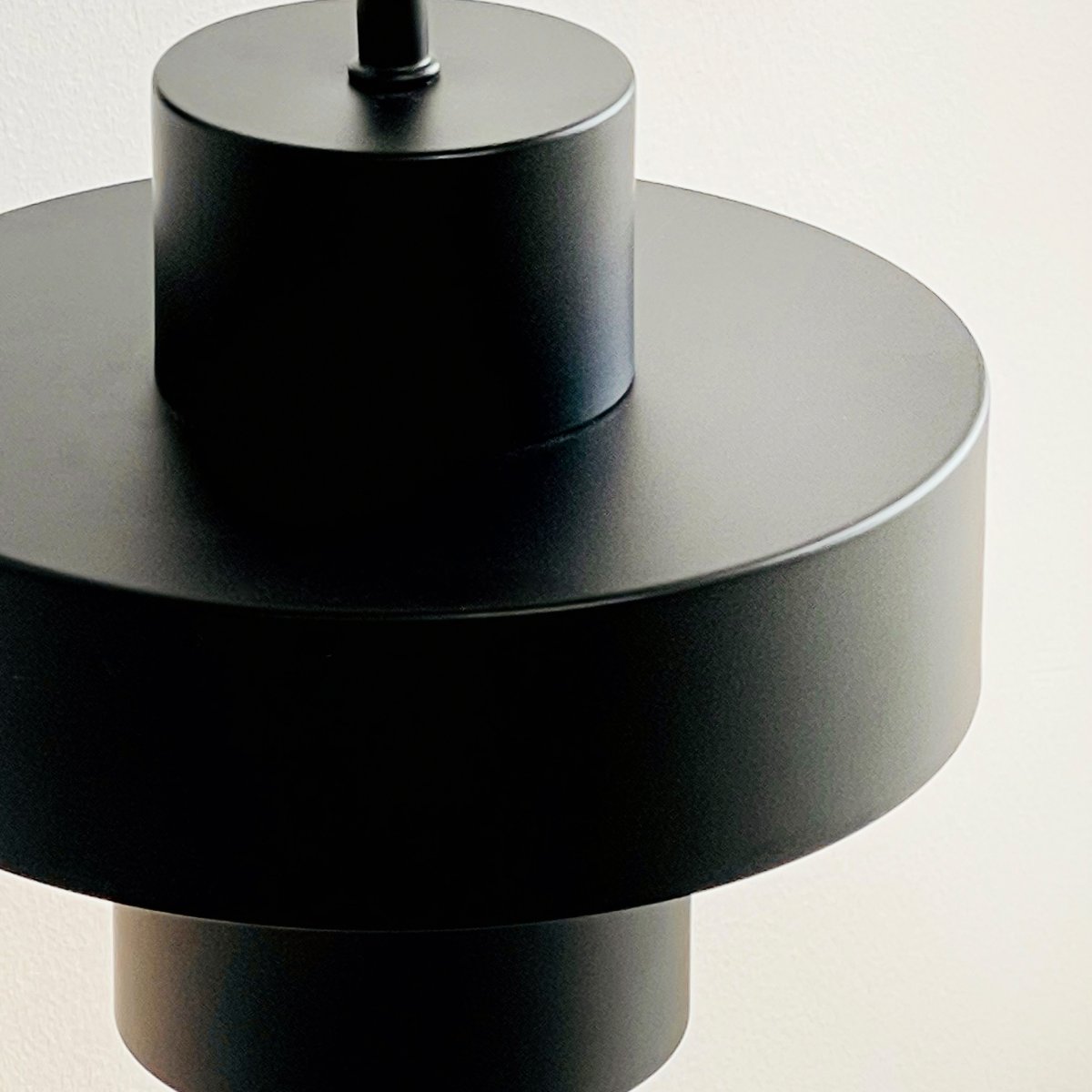 Stoke Ø15 Musta seinävalaisin valmistajalta Dyberg Larsen - Se on valmistettu metallista, jonka mattapintainen pinta korostaa valaisimen sylinterimäisiä muotoja ja luo tasapainoisen kontrastin muihin materiaaleihin, kuten kiveen, puuhun.