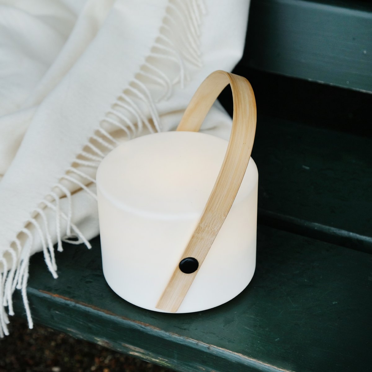 Carry 20cm Valkoinen Siirrettävä valmistajalta Dyberg Larsen - Valaisin on yhtä tyylikäs ulkoa kuin sisältäkin, ja kauniin bambukahvansa ansiosta se on helppo ottaa mukaan.