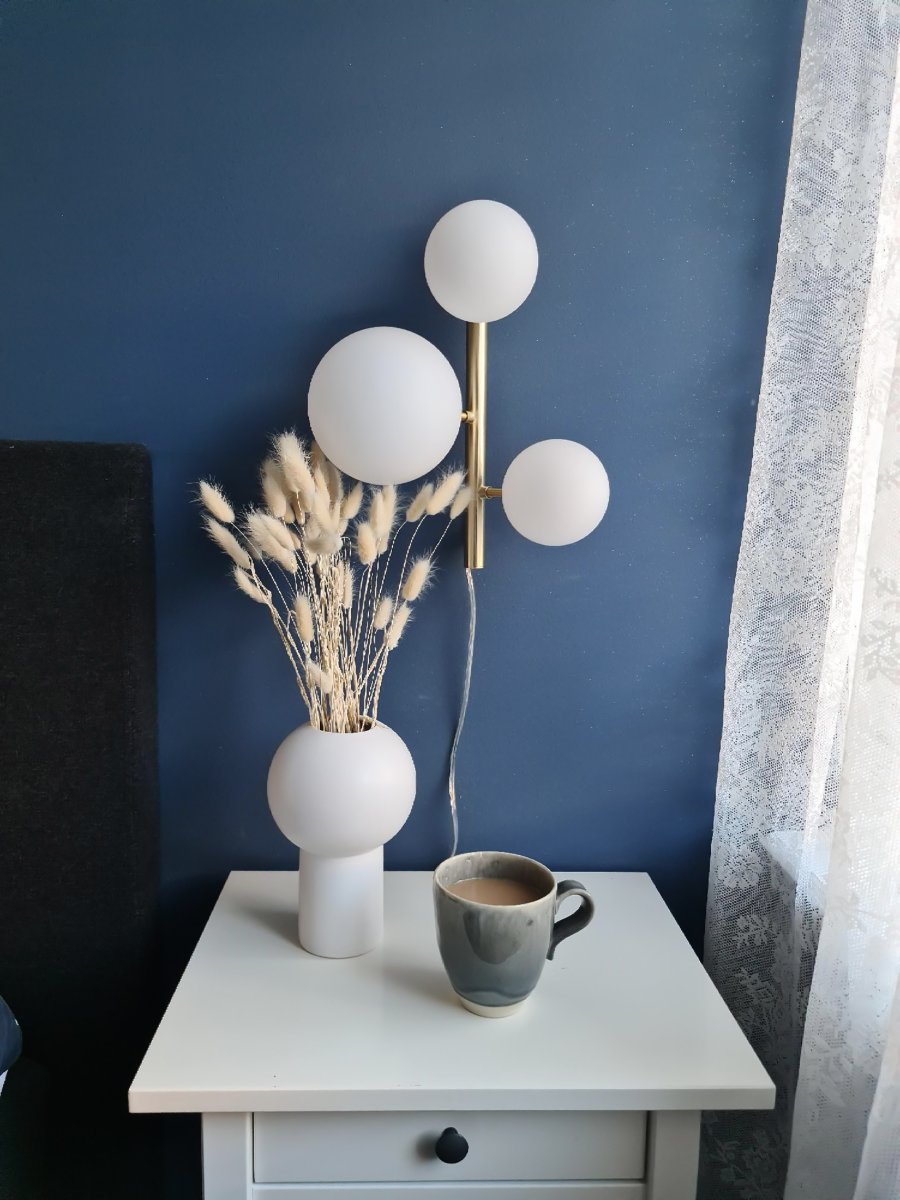 Molekyl 36cm Matta messinki seinävalaisin valmistajalta Aneta Lighting - Se on valmistettu metallista, jossa on elegantti mattamessinkipinta, ja sen opaalinvalkoiset lasivarjostimet levittävät pehmeää ja miellyttävää valoa.