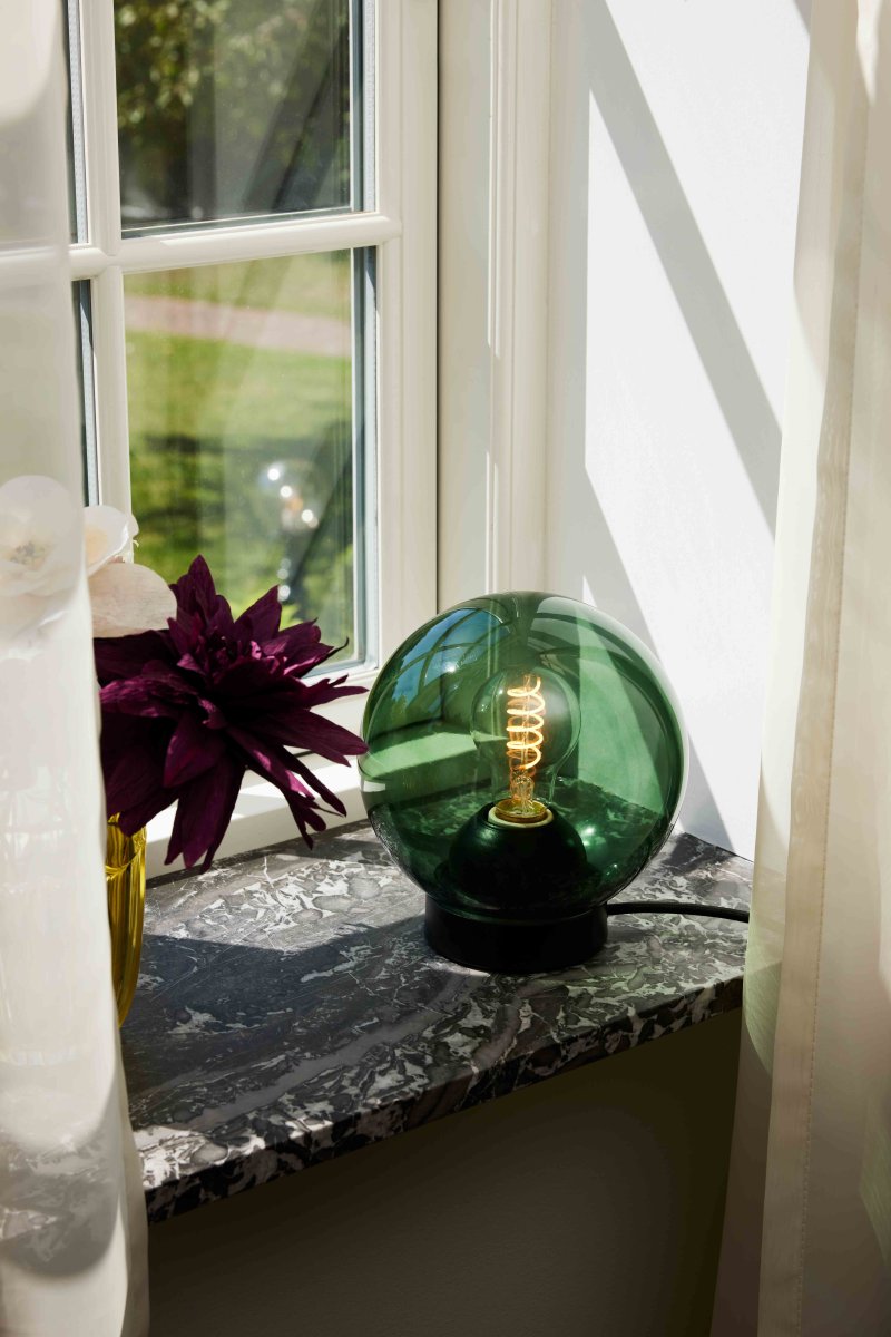 Bubbles 20cm Vihreä pöytävalaisin valmistajalta Halo Design - Vihreä lasi yhdistettynä mattamustiin metalliyksityiskohtiin lisää eleganssia ja antaa mukavan valon leviämisen huoneeseen, kun se on valaistu.