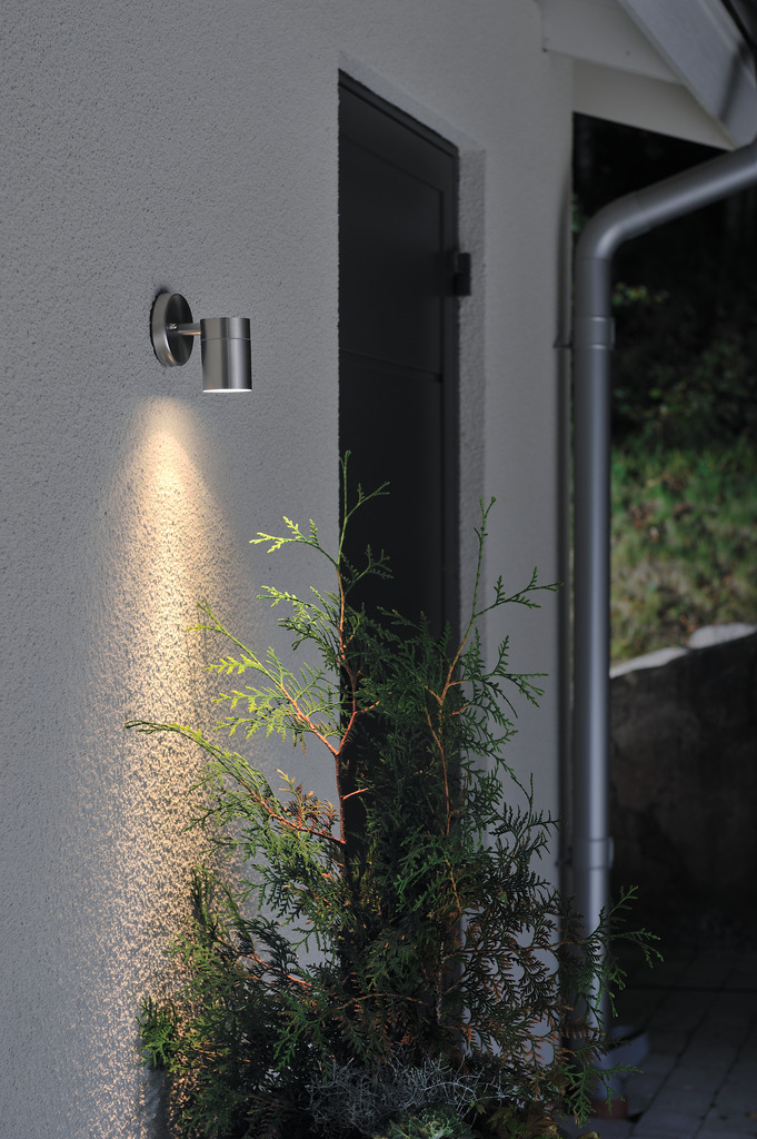 Modena Ruostumaton ulkovalo valmistajalta Konstsmide - Lamppu suuntaa valon alaspäin, mikä antaa pehmeän ja miellyttävän hehkun, joka luo turvallisuutta ja eleganssia ulkoilmaan.