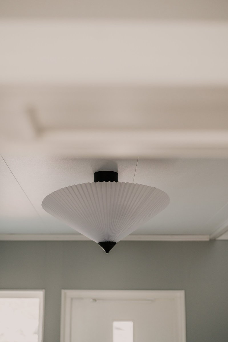 Matisse Ø60 Valkoinen plafondi valmistajalta Globen Lighting - Valaisimessa on laskostettu valkoinen tekstiilivarjostin ja sit&auml; koristaa siihen sopiva laskostettu yl&auml;osa mattamustaksi lakattua metallia.
