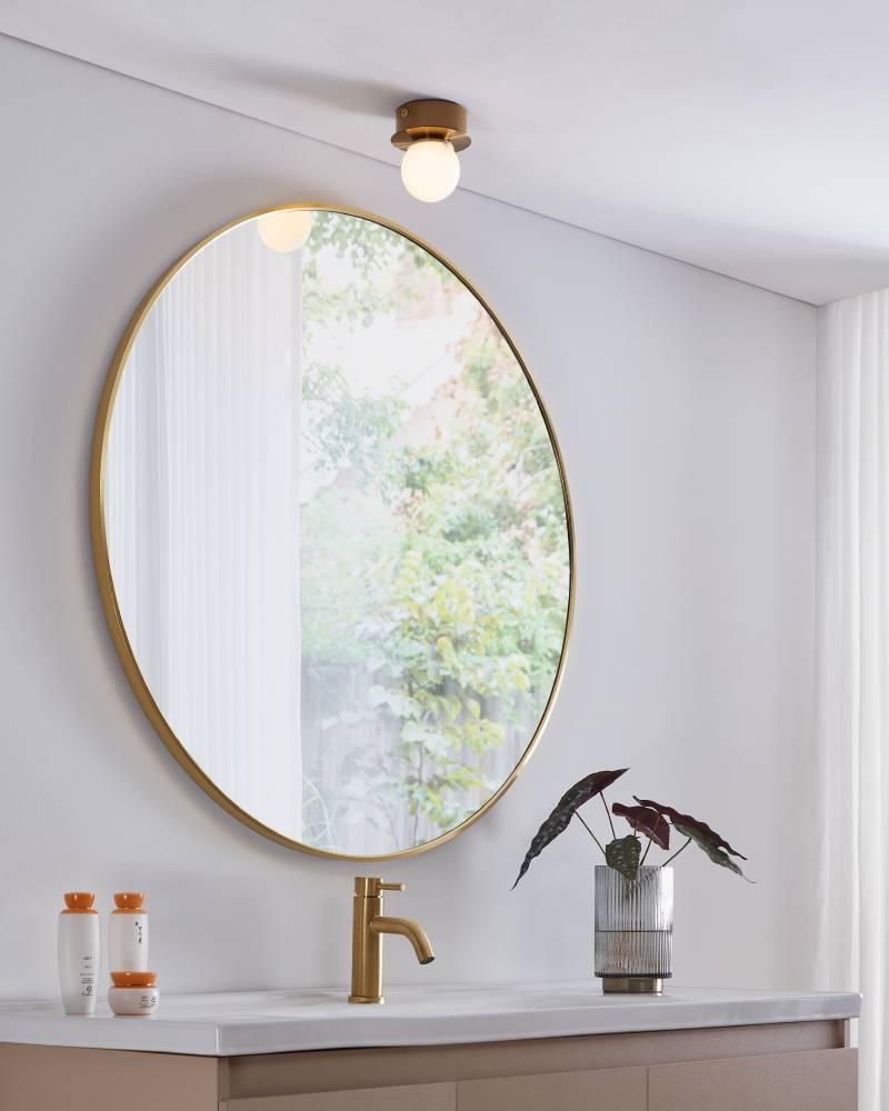 Mosiano Ø11 Kulta kylpyhuoneen valaisin valmistajalta Eglo - Pehmeän, pyöreän lasikuvun ja kullanvärisen metallipohjan ansiosta se luo lämpimän ja kutsuvan valon, joka sopii täydellisesti pienempiin tiloihin, kuten käytäviin tai kylpyhuoneisiin.