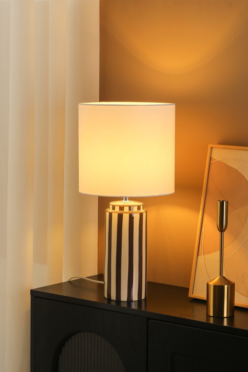Faro 50cm Ruskea/valkoinen pöytävalaisin valmistajalta Nordic Lighting - Lampunjalka on valmistettu keraamisesta materiaalista, ja siinä on kermanvalkoinen ja ruskeat raidat, jotka antavat eloisan mutta tasapainoisen vaikutelman.
