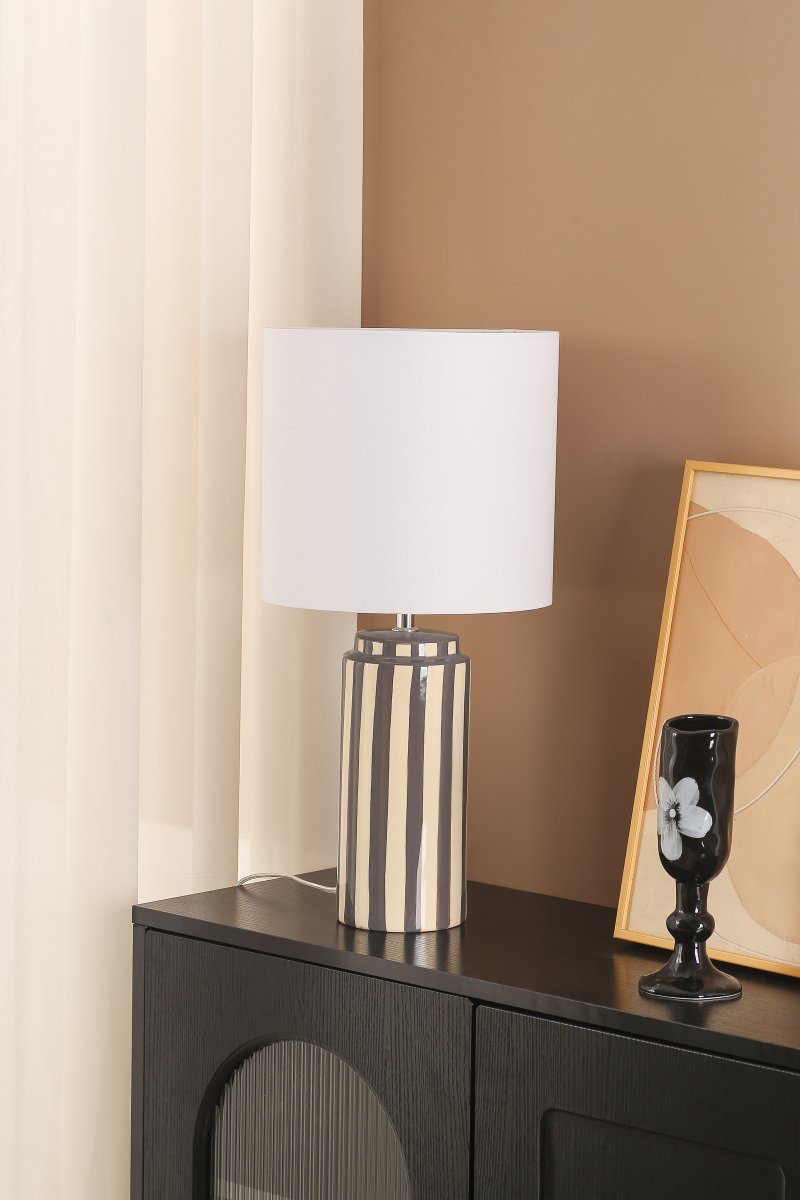 Faro 50cm Harmaa/valkoinen pöytävalaisin valmistajalta Nordic Lighting - Lampun jalka on valmistettu keraamisesta materiaalista, ja sen kermanvalkoinen jalusta ja harmaat raidat luovat eloisan mutta tasapainoisen vaikutelman.
