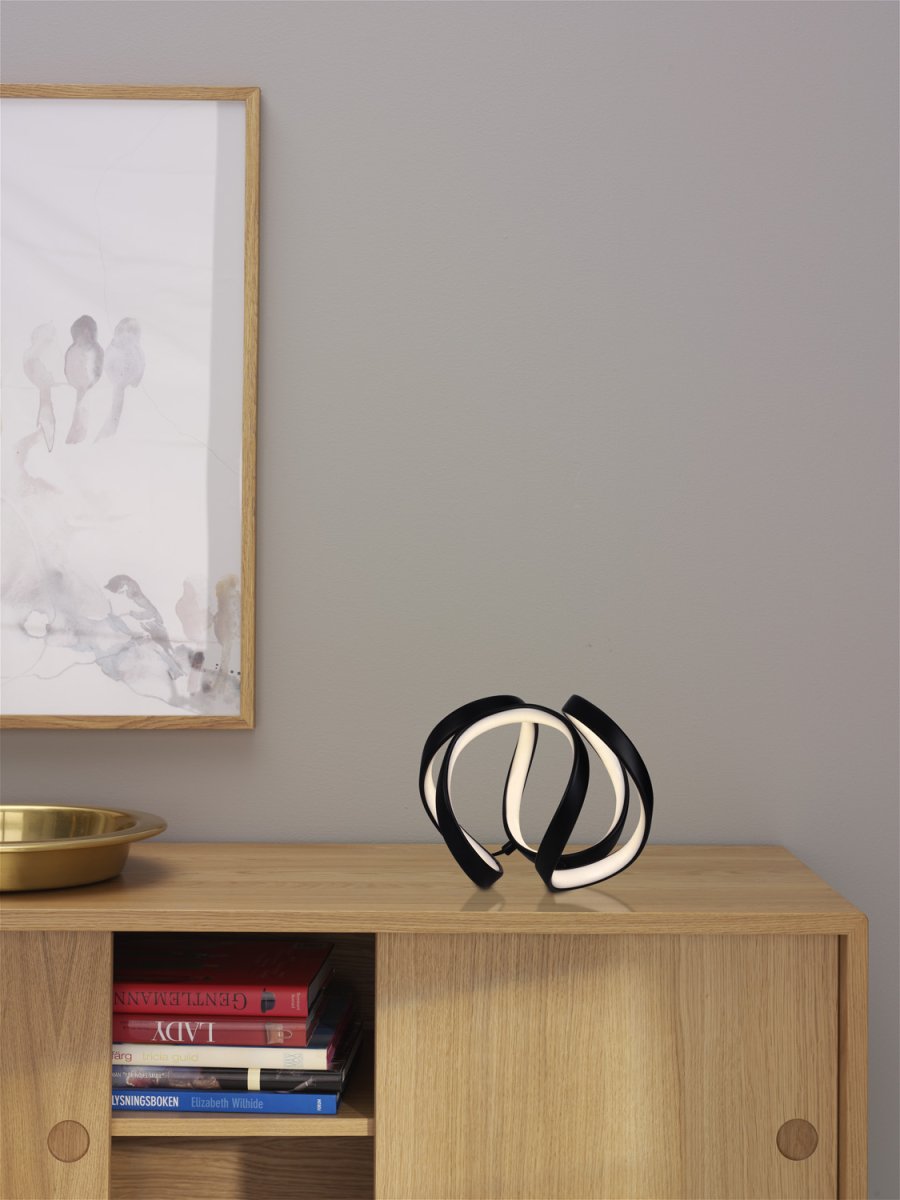 Wave 18cm Musta pöytävalaisin valmistajalta Cottex - Wave bordslampa i metall och silikon &auml;r en modern och elegant belysningsl&ouml;sning som ger ditt rum en unik och stilfull k&auml;nsla.