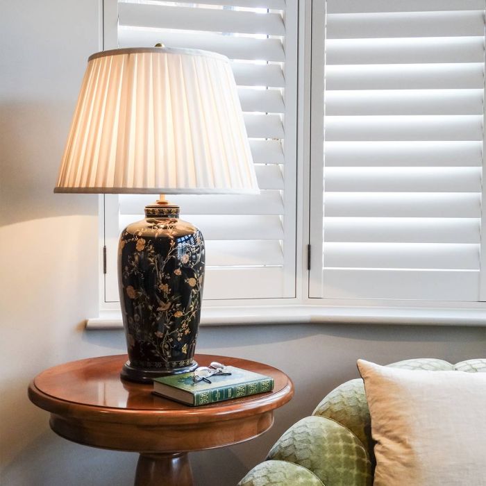 Black Birds 74cm Musta pöytävalaisin valmistajalta Elstead Lighting - Utrustad med en tr&auml;bas, veckad lampsk&auml;rm i kr&auml;mf&auml;rgad textil och en dekorativ avslutning i antikm&auml;ssing.