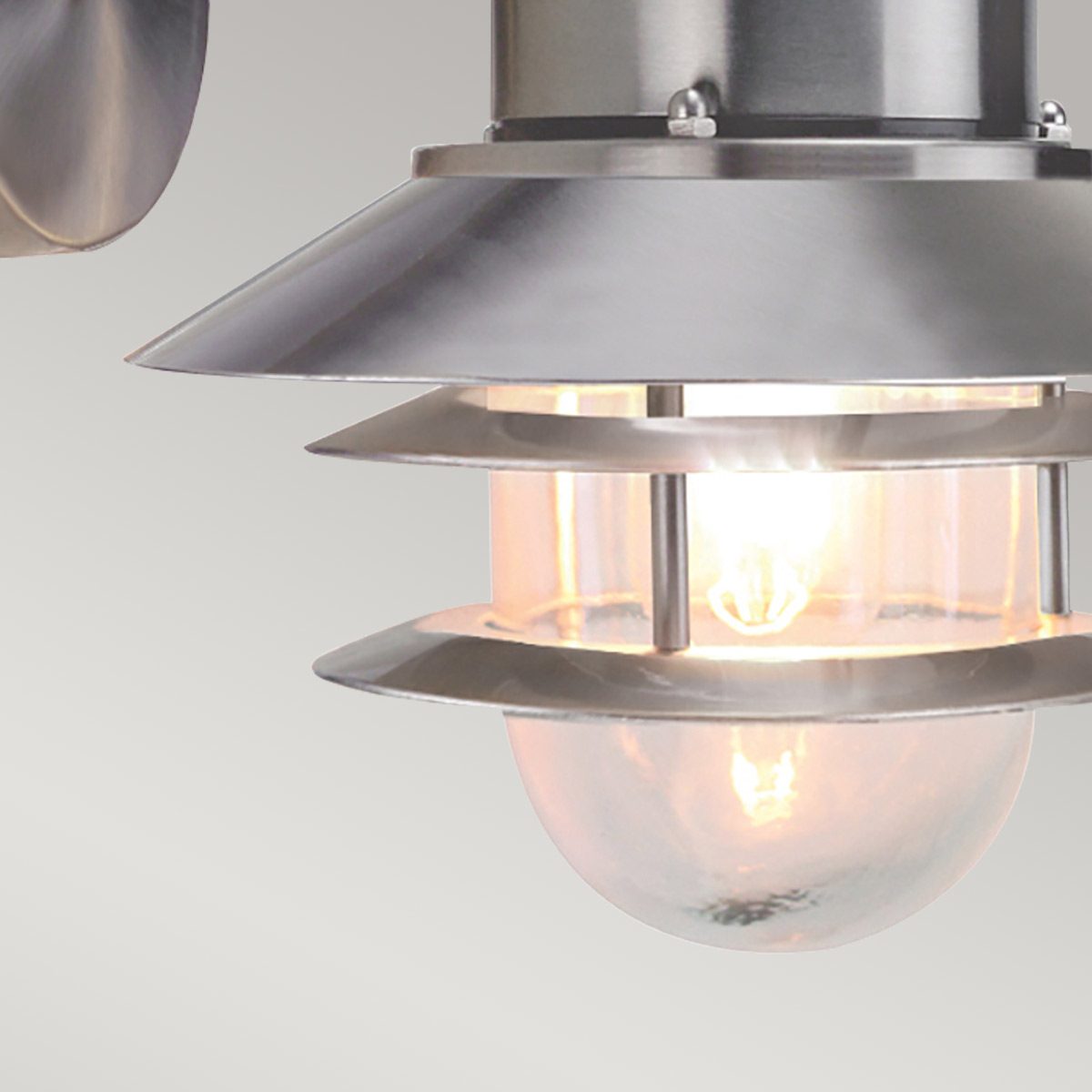 Copenhagen Ø22 Harjattua terästä ulkovalo valmistajalta Elstead Lighting - Tillverkad av rostfritt st&aring;l i borstad finish och glas, erbjuder den en h&aring;llbar och v&auml;dert&aring;lig konstruktion som passar perfekt f&ouml;r fasader, entr&eacute;er och uteplatser.