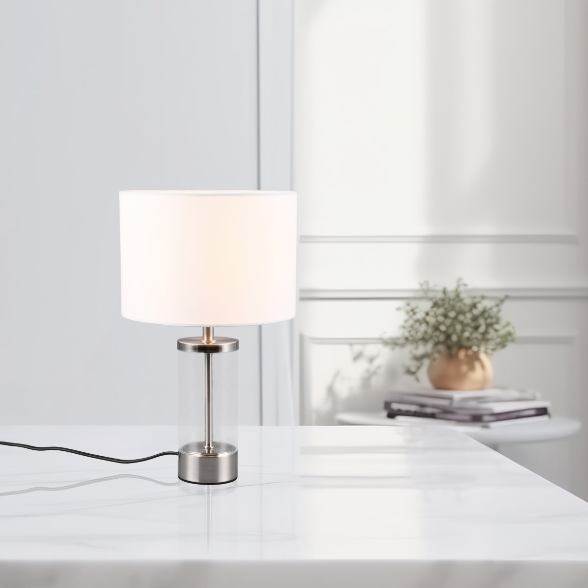 Grazia 34cm Valkoinen pöytävalaisin valmistajalta Trio Lighting - Pöytävalaisin Grazia yhdistää tyylikkään kangasvarjostimen tyylikkääseen lieriömäiseen lasi- ja metallijalkaan, mikä antaa harmonisen ja hienostuneen vaikutelman.