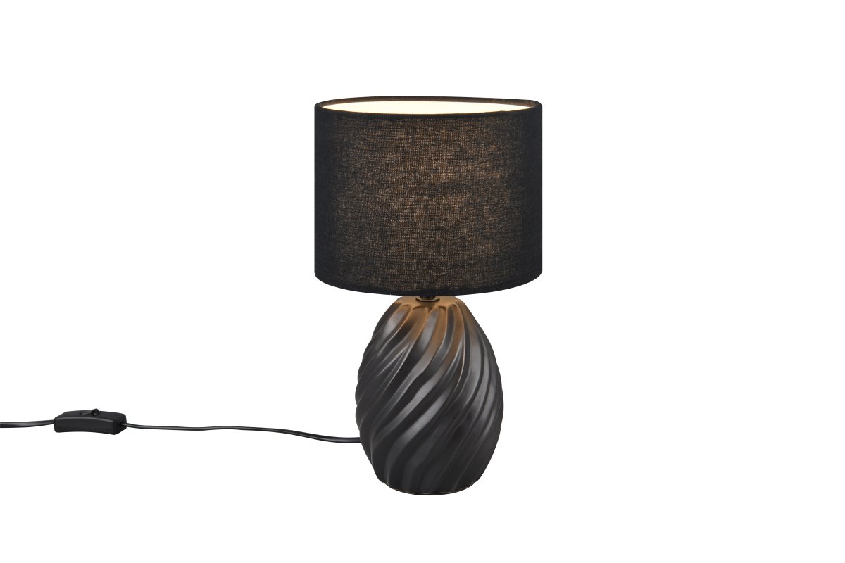 Melva 30cm Musta pöytävalaisin valmistajalta Trio Lighting - Tyylikäs sekoitus mattamustaa keramiikkaa ja pehmeää kangassävyä antaa hienostuneen vaikutelman, kun taas aallonmuotoinen keraaminen pohja luo kiehtovan valon leikin.