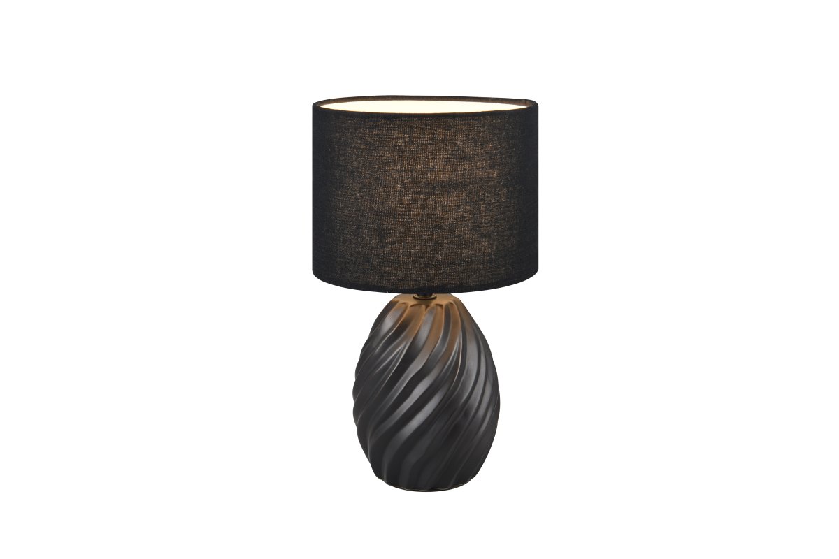Melva 30cm Musta pöytävalaisin valmistajalta Trio Lighting - Tyylikäs sekoitus mattamustaa keramiikkaa ja pehmeää kangassävyä antaa hienostuneen vaikutelman, kun taas aallonmuotoinen keraaminen pohja luo kiehtovan valon leikin.
