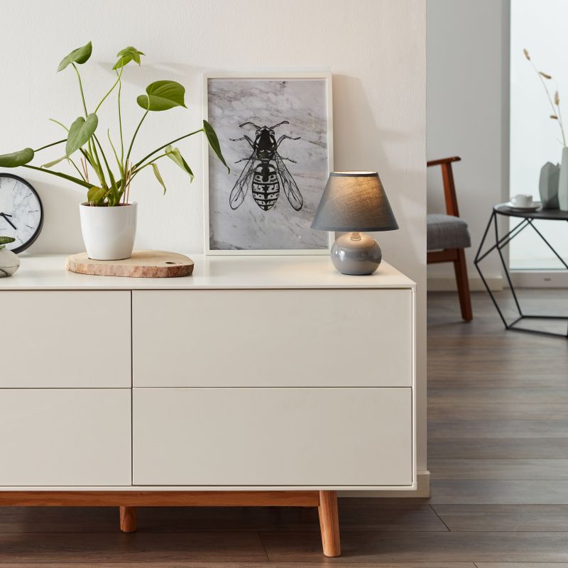 Primo 23cm Tummanharmaa pöytävalaisin valmistajalta Brilliant - Se on valmistettu tekstiilist&auml; ja keramiikasta ja antaa miellytt&auml;v&auml;n valon.