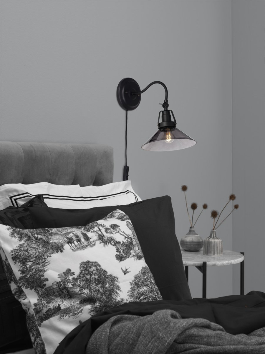 Suutarinlamppu Ø20 Musta seinävalaisin valmistajalta Cottex - Mustan metallin ja savustetun lasin yhdistelm&auml; luo eleganssia ja tarjoaa hienon valon diffuusion.